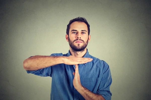 Young man giving showing time out hands gesture